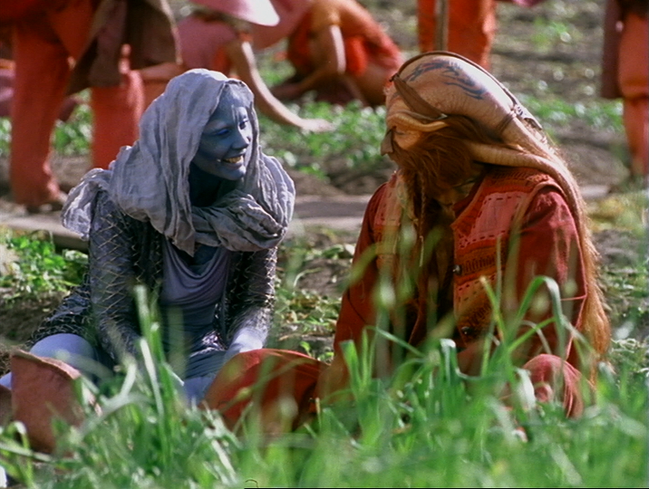 Screencap from the episode showing Zhaan (left) and D'Argo happily harvesting tannot root in a field.